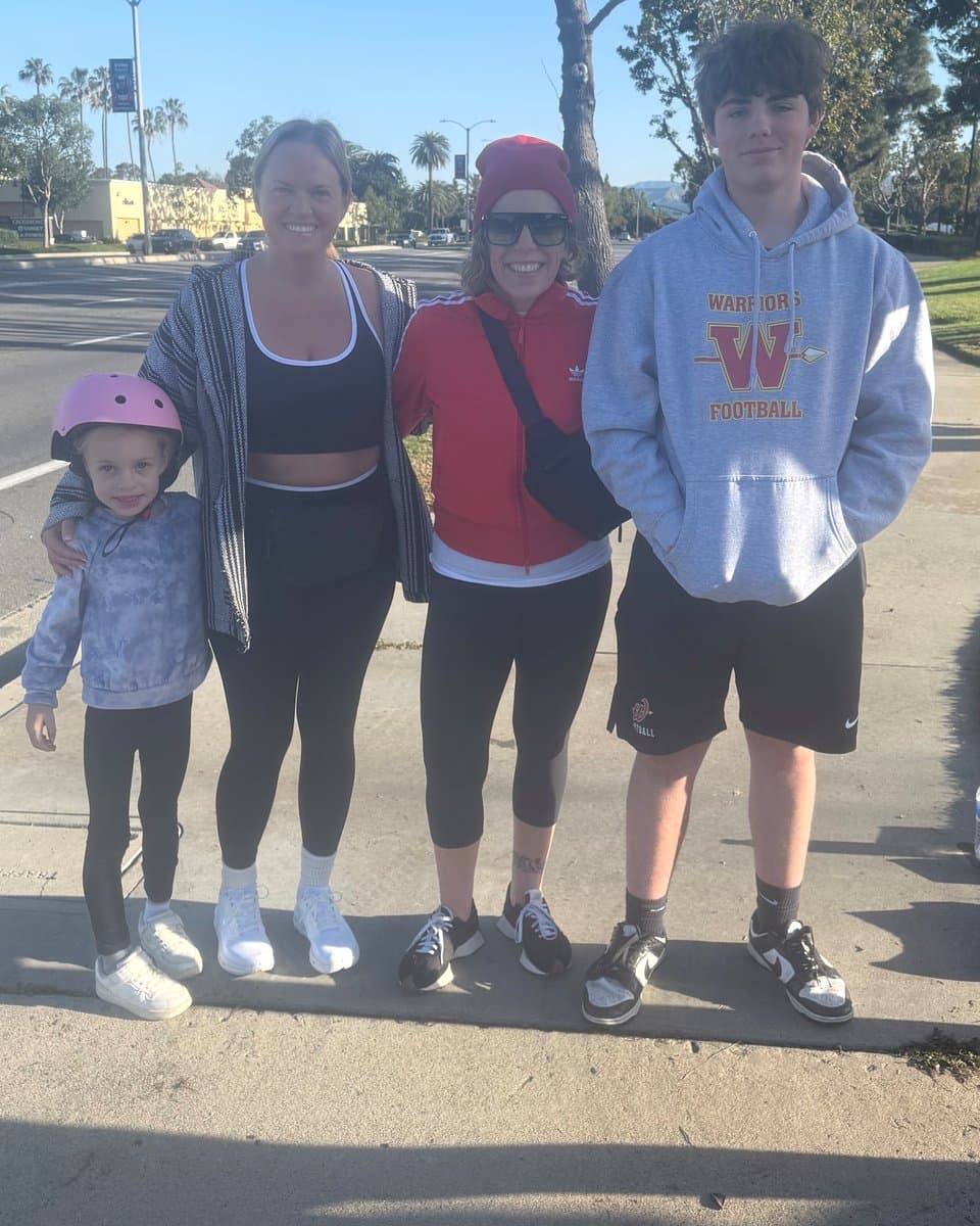 Nikki Yeager in a red jacket and beanie next to her son in a Warriors Football hoodie